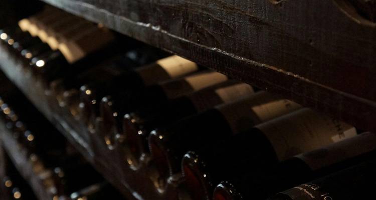 Cave sombre avec des bouteilles de vin sur les étagères.