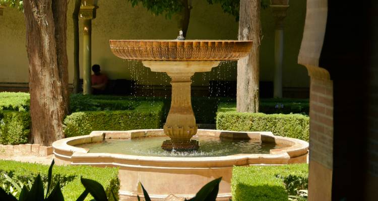 Fontaine avec de l'eau qui coule dans un cadre de jardin.