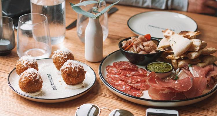 Tisch mit verschiedenen Wurst- und Fleischwaren und Tapas.