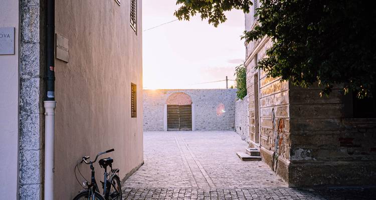Ruelle tranquille avec un vélo et une douce lumière du soleil filtrée