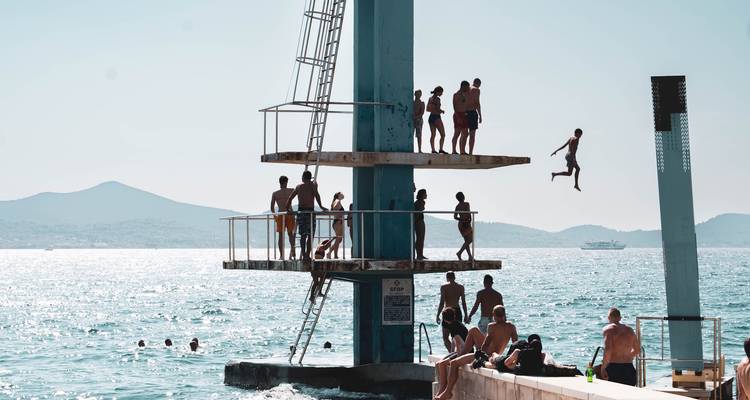 Des gens se sont rassemblés sur un plongeoir au bord de la mer