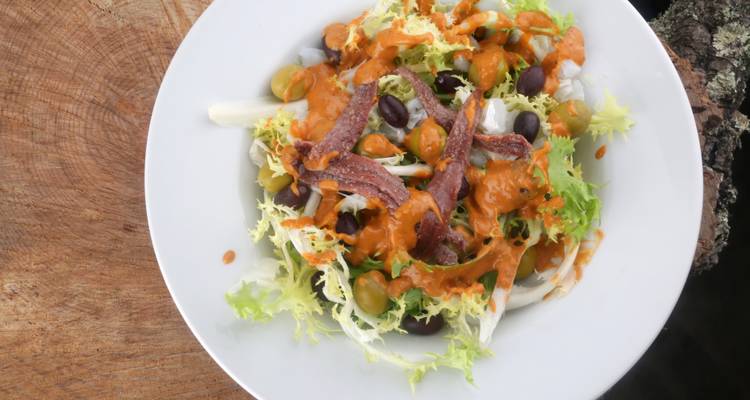 Plate of salad with anchovies and olives.