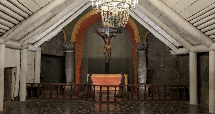 An underground chapel with a crucifix and chandeliers.
