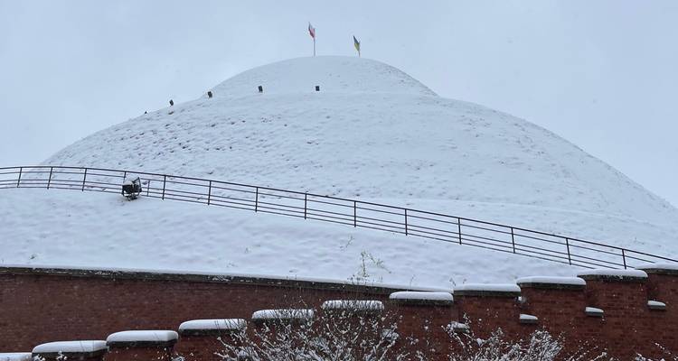 A snow-covered mound with flags on top.
