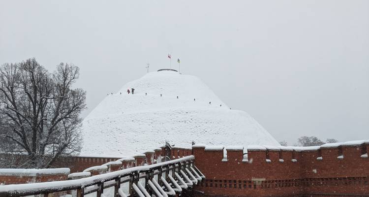 Path leading to a snow-covered mound with flags.