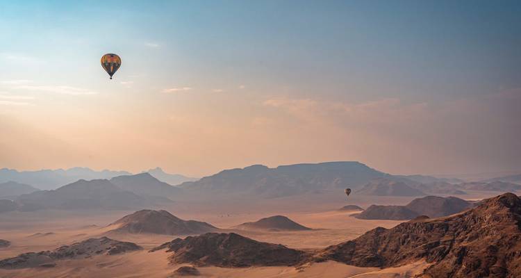 Montgolfières au-dessus d'un paysage désertique.