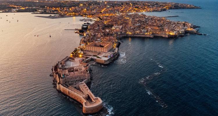 Vue aérienne d'une péninsule urbaine entourée d'eau au crépuscule.