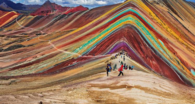 Chaîne de montagnes colorée en couches avec des randonneurs.