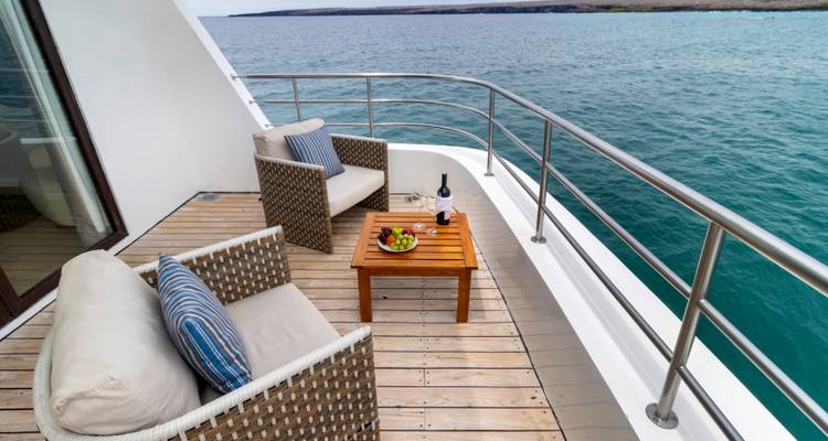 Deck with chairs and table overlooking the sea.
