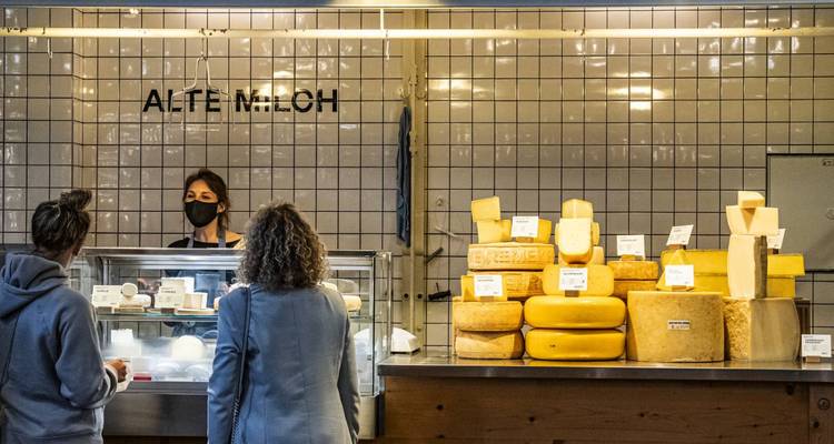 Des personnes achetant du fromage dans un marché local.