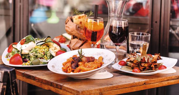 Cuisine italienne avec des boissons sur une table en plein air.