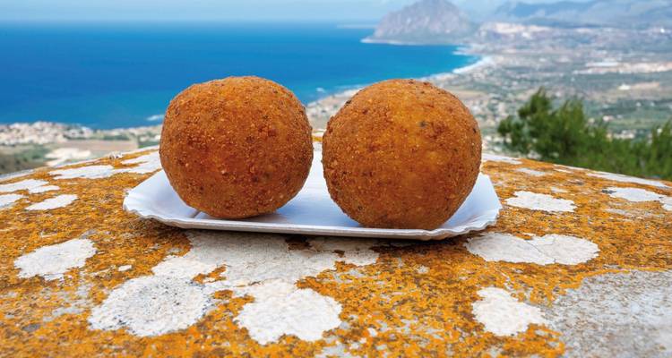 Deux arancini sur un belvédère avec vue sur la côte.