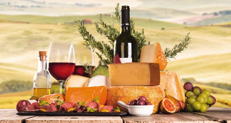 Selectie van kazen en wijn met een schilderachtige achtergrond.