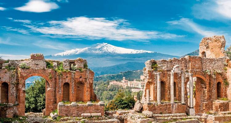 Antike Ruinen mit einem schneebedeckten Berg im Hintergrund.