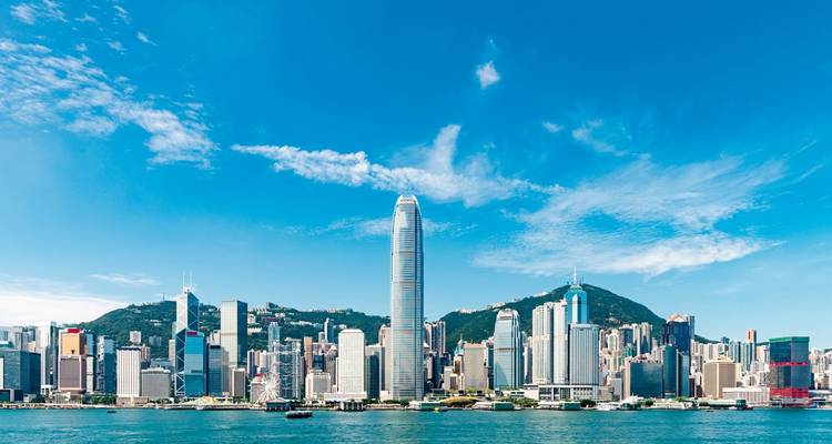 Skyline of a city with a prominent tall building by the waterfront.