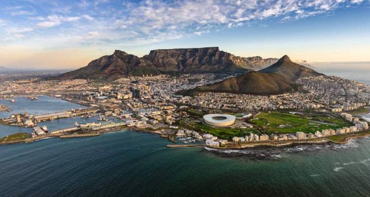 Aerial view of city with large stadium by the sea.