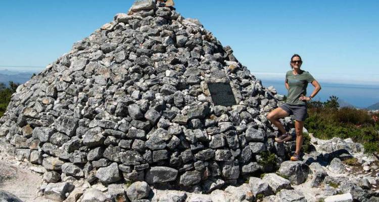 Person standing on rock structure posing for a photo.