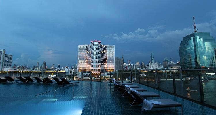 Wolkenkrabbers bekeken vanaf een zwembad op het dak.