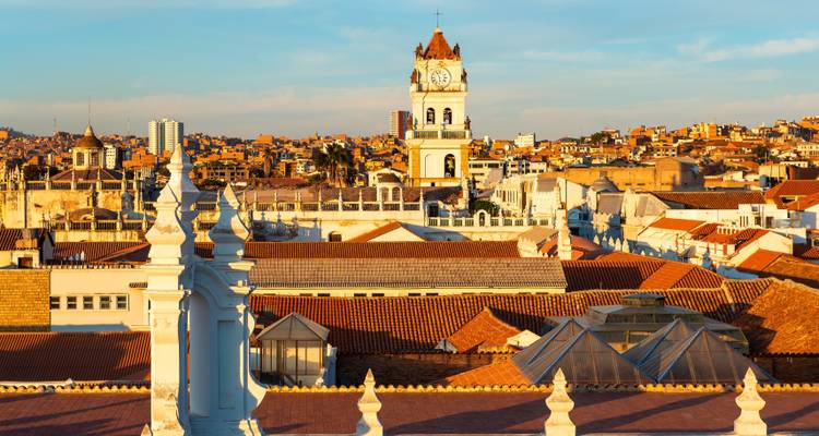 La luz dorada del atardecer baña los tejados coloniales y las torres de la catedral del centro histórico de Sucre.
