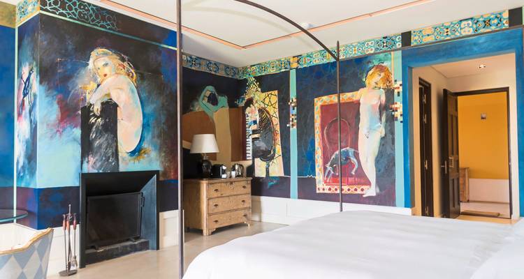 Artistic hotel room with vibrant murals and modern design.