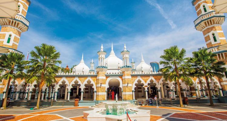 Mosque courtyard with palm trees and fountains.