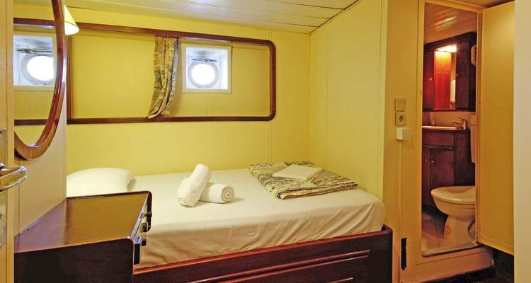 Cabin room on a ship with portholes and basic amenities.