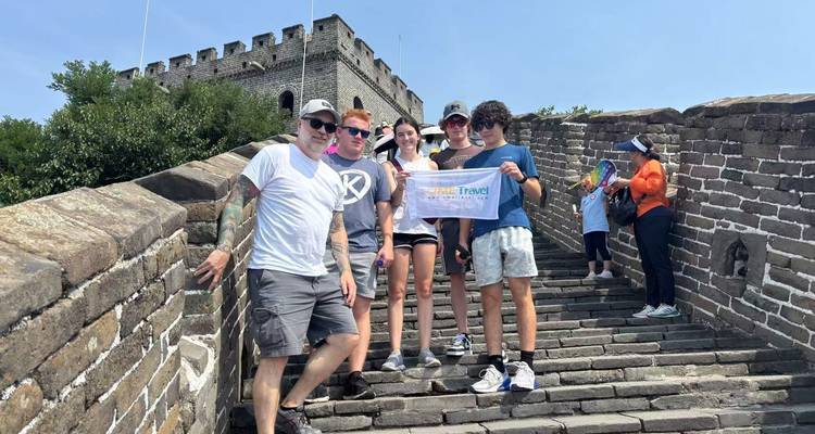 Toeristen op de Chinese Muur met een groepsbanner.