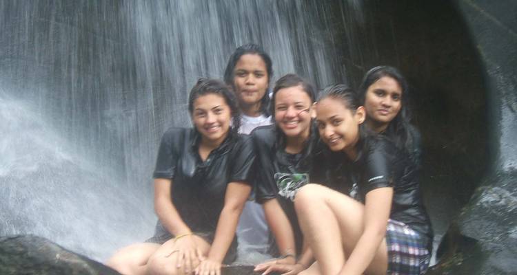 Group of women sitting under a waterfall.