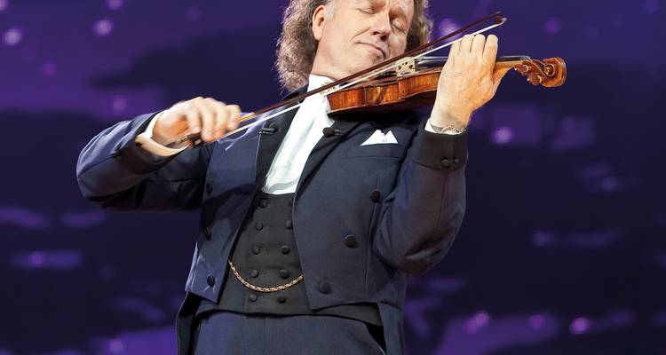 Violinist playing with passion on stage.