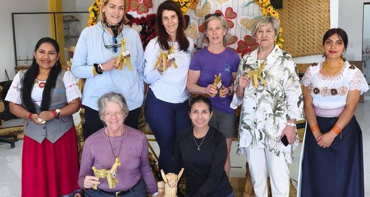 Groupe de participants tenant fièrement des figurines artisanales après un atelier culturel.