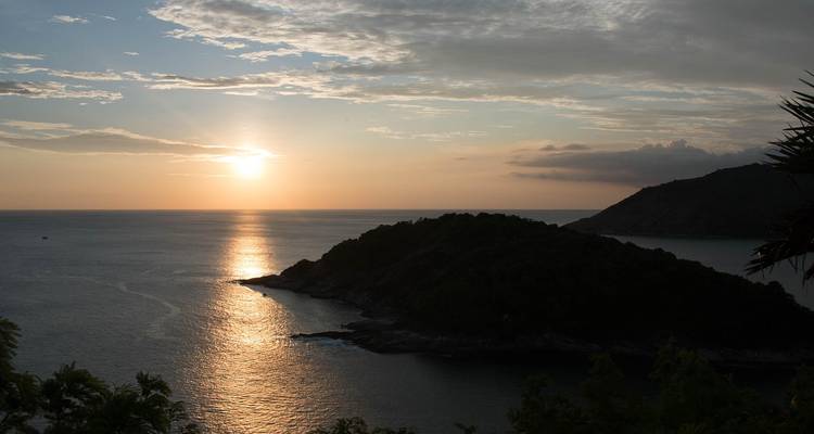 Une vue pittoresque de coucher de soleil sur l'océan avec des îles en silhouette.