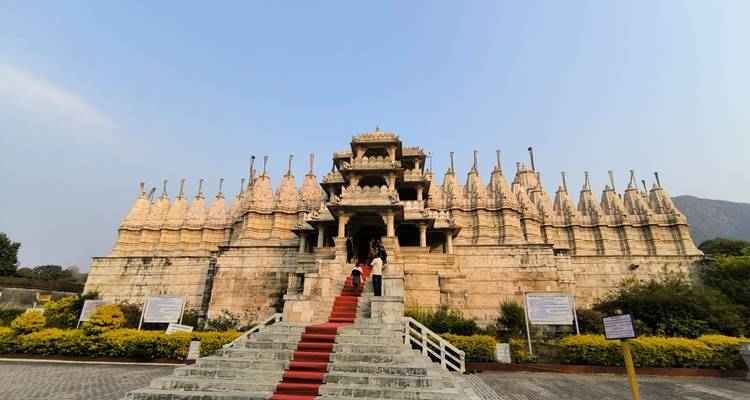 Ranakpur Jain Tempel mit rotem Teppicheingang und Besuchern auf den Stufen.
