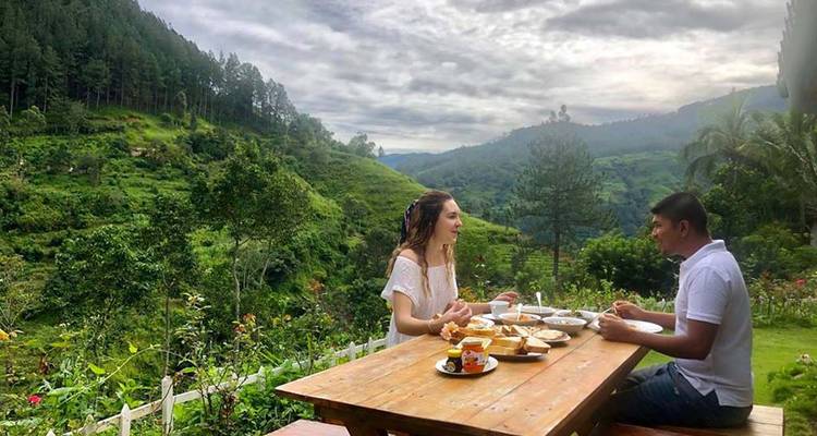 Two people dining outdoors with a scenic view