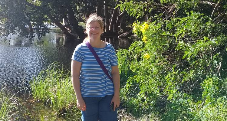 Woman standing by a scenic river