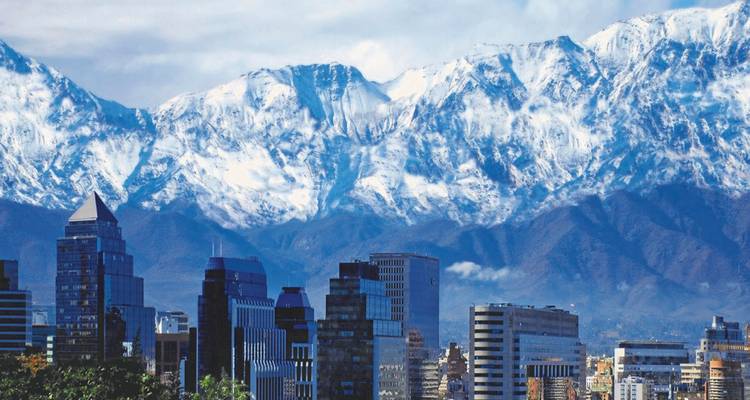 Paysage urbain avec gratte-ciel et montagnes enneigées des Andes en arrière-plan.