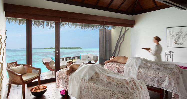 Spa-Raum mit zwei Massageliegen mit Blick auf das tropische Meer.