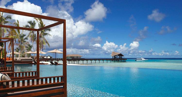 Luxuriöse Overwater-Villen mit Pool und Palmen am Strand