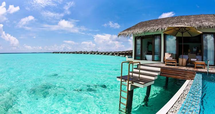 Villa über dem Wasser mit direktem Zugang zu türkisfarbenem Wasser und klarem blauen Himmel