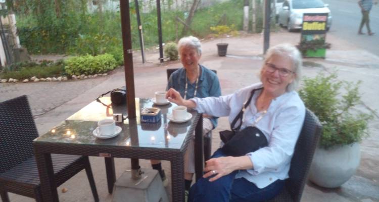 Deux femmes âgées assises à une table de café avec du café.
