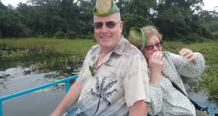 Couple âgé dans un bateau portant des chapeaux de feuilles.