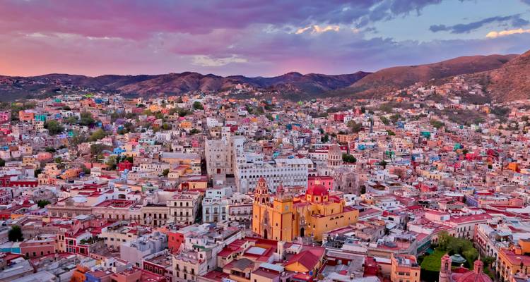 Colorful aerial view of a city with vibrant buildings during sunset.