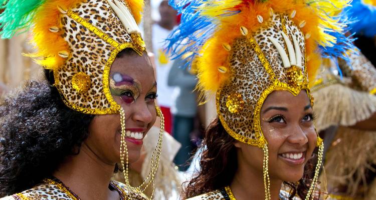 Two women in vibrant Carnival costumes smiling.