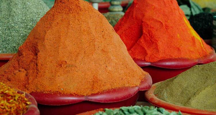 Mounds of colorful spices in a market.