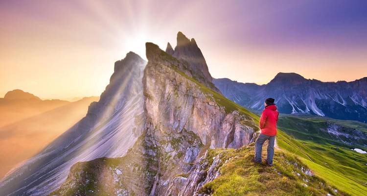Personne profitant d'une vue panoramique sur la montagne avec soleil et nuages.
