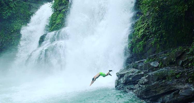 Personne plongeant près d'une cascade.