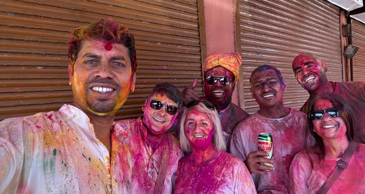 Selfie de groupe de personnes souriantes et recouvertes de poudres colorées de Holi.