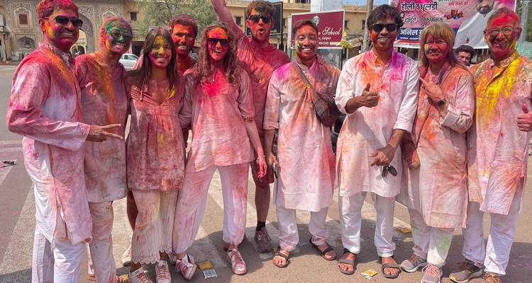 Groupe de personnes couvertes de poudre colorée pendant un festival.
