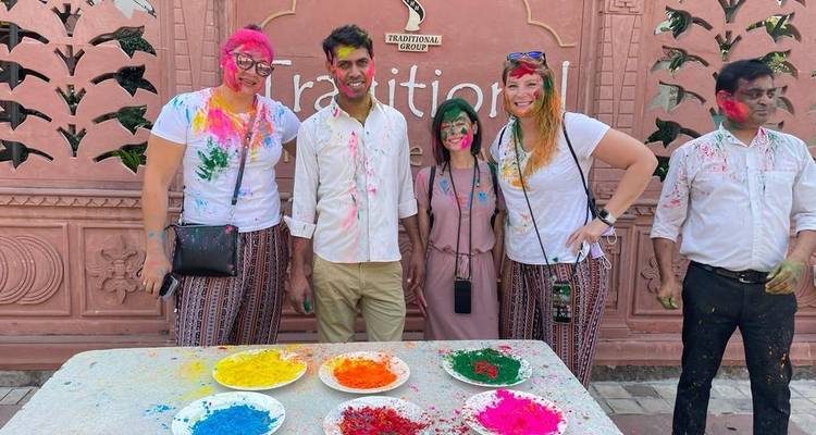 Des personnes posant près d'une table avec des bols de poudre colorée.