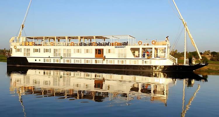 Riverboat Sekhmet sailing on a calm river.