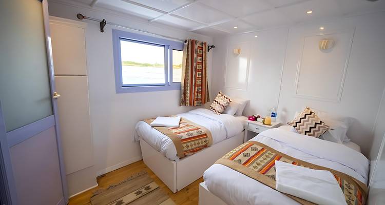Interior of a small room with twin beds and river view.